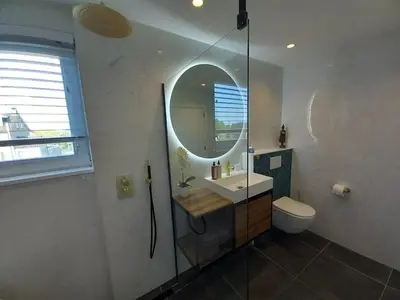 a bathroom with a sink and a mirror and a toilet at Luxurious house close to the center of Amsterdam in Oostzaan