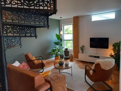 a living room with a couch and chairs and a tv at Luxurious house close to the center of Amsterdam in Oostzaan