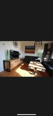 a living room with a couch and a tv at Vakantiehuis Medemblik polder in Opperdoes