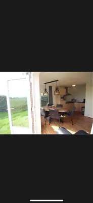 a living room and a dining room with a table at Vakantiehuis Medemblik polder in Opperdoes