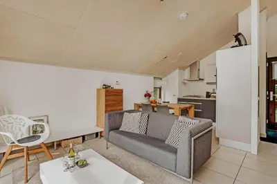 a living room with a couch and a kitchen at Dutchen Vakantiepark Buiten Bergen in Schoorl