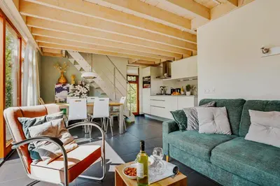 a living room with a green couch and a table at Dutchen Vakantiepark Buiten Bergen in Schoorl