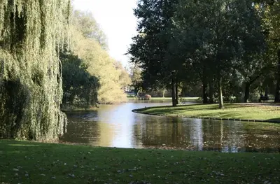 a river in a park with trees and grass at Stunning artist zen guest suite at heart of Amsterdam in Amsterdam