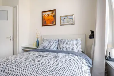 a bedroom with a bed with a blue and white comforter at Stunning artist zen guest suite at heart of Amsterdam in Amsterdam
