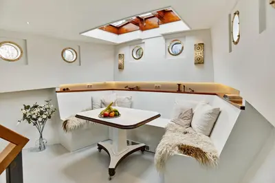 a dining room with a table and a bench at Your Houseboat Amsterdam in Amsterdam