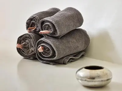 a pile of towels sitting next to a vase at Your Houseboat Amsterdam in Amsterdam