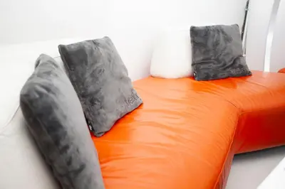 two pillows sitting on top of an orange bed at Modern Central Leiden Family Apt - Sleeps 6 and Baby in Leiden