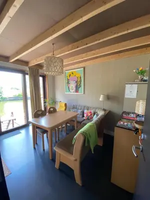 a dining room with a table and chairs and a kitchen at T kan Verkeren - Houseboat in Amsterdam