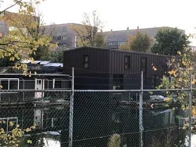 a train car is sitting on top of a fence at T kan Verkeren - Houseboat in Amsterdam