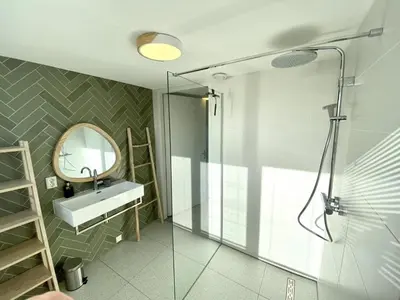a bathroom with a shower and a sink and a mirror at Stunning villa near beaches and golf course in Sint Maarten