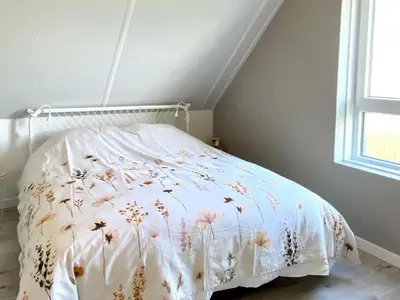 a bed with a white blanket with flowers on it at Stunning villa near beaches and golf course in Sint Maarten