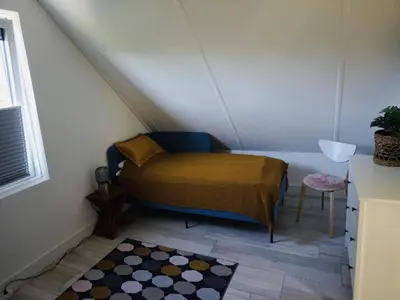 a small bedroom with a bed in a attic at Beautiful Villa close to beaches in Sint Maarten