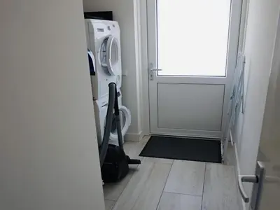 a laundry room with a washing machine and a door at Beautiful Villa close to beaches in Sint Maarten