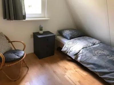 a small bedroom with a bed and a night stand at Pretty holiday home in Burgerburg in Burgerbrug