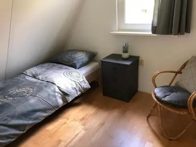 a bedroom with a bed and a table and a chair at Pretty holiday home in Burgerburg in Burgerbrug