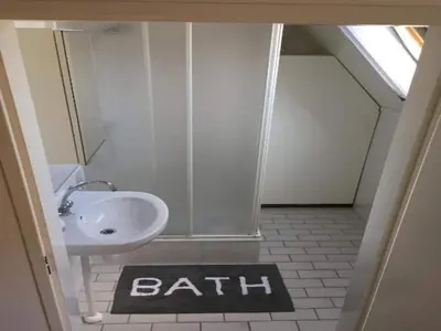 a bathroom with a sink and a bath sign on the floor at Pretty holiday home in Burgerburg in Burgerbrug