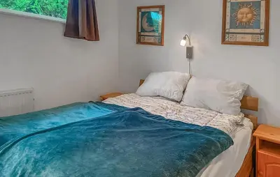 a bedroom with a bed with a blue blanket on it at Pet Friendly Home In Dirkshorn in Dirkshorn