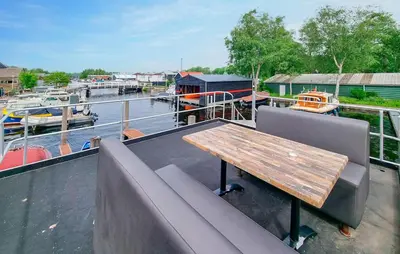 a wooden table and chairs on a boat deck at Havenlodge Amsterdam 1 in Amsterdam