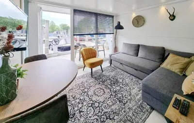 a living room with a table and a couch at Havenlodge Amsterdam 1 in Amsterdam
