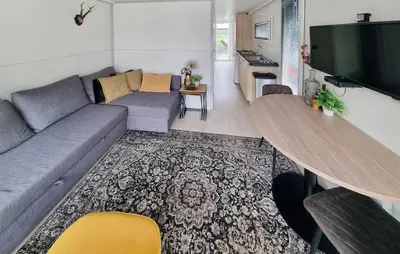 a living room with a couch and a flat screen tv at Havenlodge Amsterdam 1 in Amsterdam