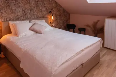 a bedroom with a large bed with white sheets and pillows at Enjoy Heaven in Schellinkhout