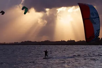 a man kite surfing in the water at sunset at Enjoy Heaven in Schellinkhout