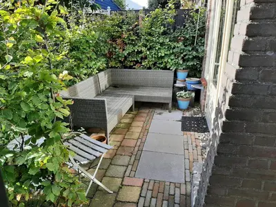 a garden with a bench and a garden sidx sidx sidx at Gezellig souterrain in bollestreek met prive ingang in Hillegom