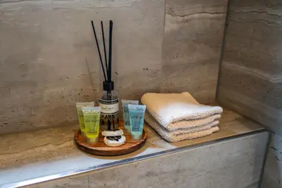 a bathroom counter with a bottle and some glasses at B&B Wellness 'De Bourgondische Lelie' in Bunschoten