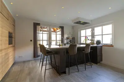 a kitchen with a large island with bar stools at B&B Wellness 'De Bourgondische Lelie' in Bunschoten