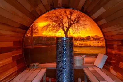 a round window in a cabin with a tree in it at B&B Wellness 'De Bourgondische Lelie' in Bunschoten