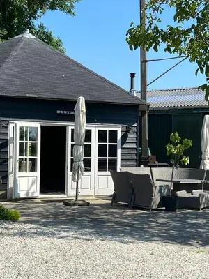 a patio with an umbrella and a table and chairs at De Gouwe Leeuw in Woerdense Verlaat