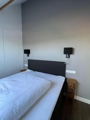 a bedroom with a white bed with two lights on the wall at De Gouwe Leeuw in Woerdense Verlaat