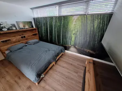 a bedroom with a bed and a large window at Beautiful apartment close to sea Beach Life 51A in Noordwijk