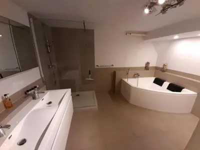 a white bathroom with a tub and a sink at Beautiful apartment close to sea Beach Life 51A in Noordwijk