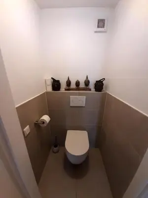 a small bathroom with a toilet with black cats on the shelf at Beautiful apartment close to sea Beach Life 51A in Noordwijk