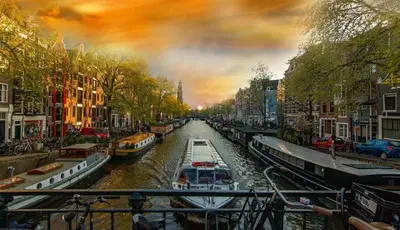 a view of a canal with boats in a city at Gateway to Amsterdam in Almere