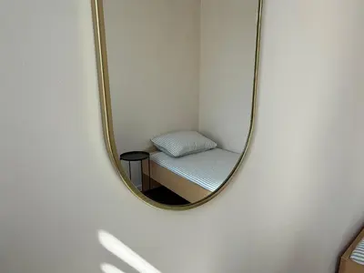 a mirror on a wall with a chair in a room at Gateway to Amsterdam in Almere