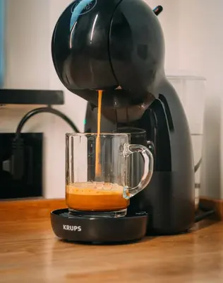 a coffee maker is pouring coffee into a cup at La Casa de Moerkapel in Moerkapelle
