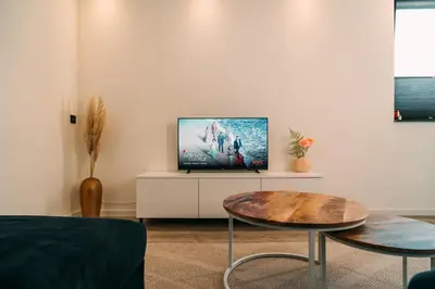 a living room with a tv and a table at La Casa de Moerkapel in Moerkapelle