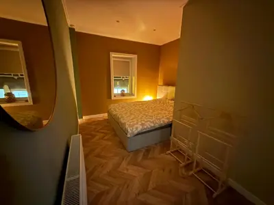 a bedroom with a bed and a mirror at cozy apartment in the centre of Gouda in Gouda