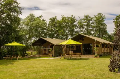 a building with yellow umbrellas in a yard at Zorgcamping De Ruif De zilverberk in Stoutenburg