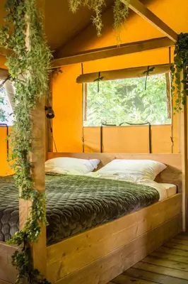 a bedroom with two beds and a window at Zorgcamping De Ruif De zilverberk in Stoutenburg
