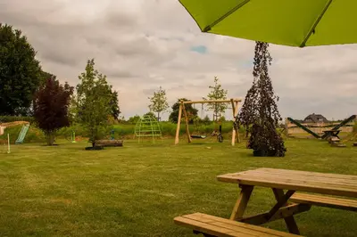 a park with a picnic table and an umbrella at Zorgcamping De Ruif De zilverberk in Stoutenburg