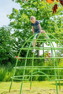 a young boy standing on top of a green ladder at Zorgcamping De Ruif De zilverberk in Stoutenburg