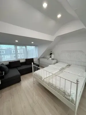 a bedroom with a white bed and a couch at Deluxe Estate in Hoofddorp