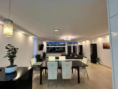 a dining room and living room with a table and chairs at Deluxe Estate in Hoofddorp