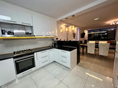 a kitchen with white cabinets and a dining room at Deluxe Estate in Hoofddorp