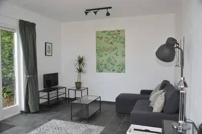 a living room with a couch and a tv at Guesthouse 70m2 with private garden and free parking in Rijnsburg