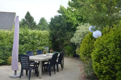 a table with black chairs sitting around it at Guesthouse 70m2 with private garden and free parking in Rijnsburg