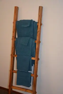 a stack of blue towels on a wooden ladder at Guesthouse 70m2 with private garden and free parking in Rijnsburg